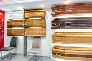 Exposition de modèles de cercueils en bois dans la salle de présentation d'une agence funéraire