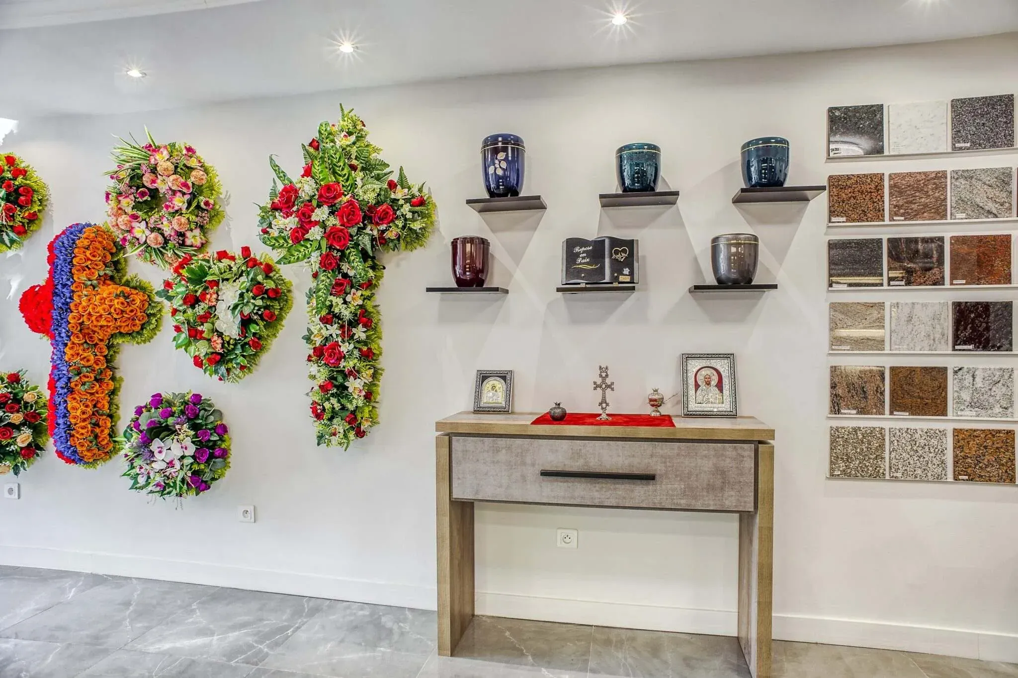Exposition de couronnes de fleurs de deuil, d'urnes funéraires et d'échantillons de granit marbrerie
